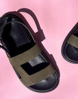 Black and khaki sandals on a pink background