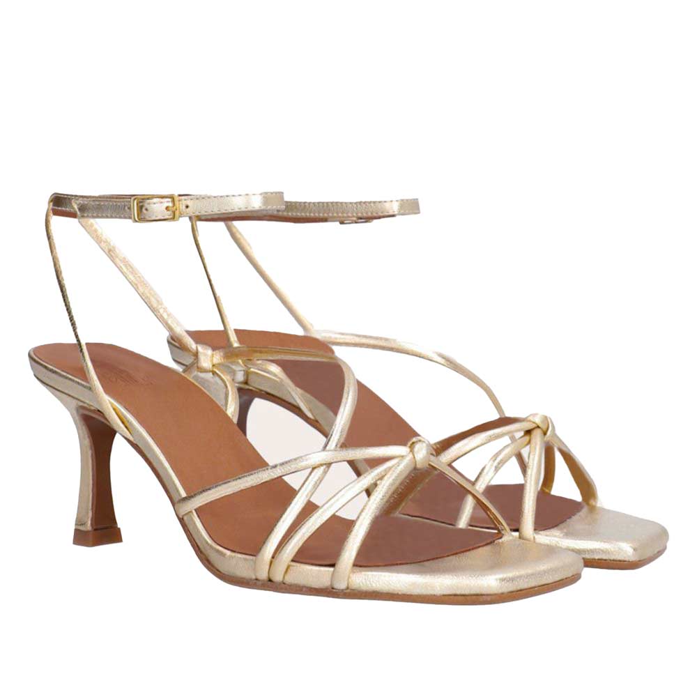 Gold high-heeled sandals on a white background