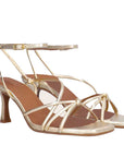 Gold high-heeled sandals on a white background