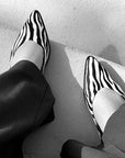 Black and white zebra-striped shoes on a light background