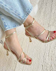 top view of Mi/Mai Venice strappy sandal with ankle strap in soft metallic gold leather styled with light wash denim jeans