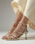 Mi/Mai Venice strappy sandal with ankle strap in soft metallic gold leather styled with cream trousers for spring
