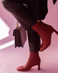 Mi/Mai Darcy mid heel ankle boot in red leather onn model wearing black jeans and sweater with black bag