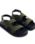 Pair of green sandals with black soles on a white background