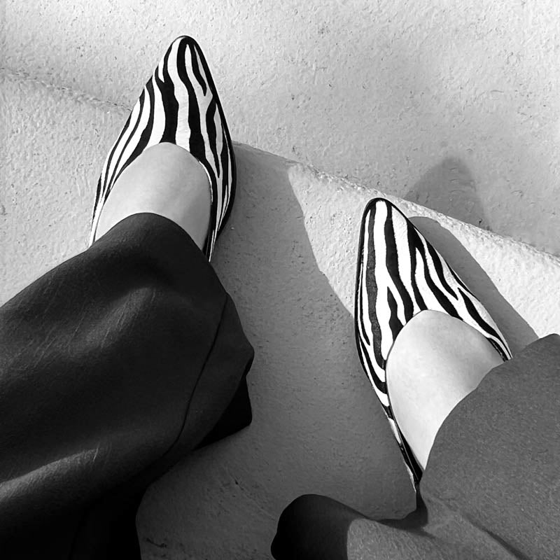 Black and white zebra-striped shoes on a light background