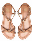 Pair of tan sandals with gold straps on a white background