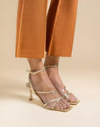 Mi/Mai Venice strappy sandal  with ankle strap in soft metallic gold leather styled with orange trousers 