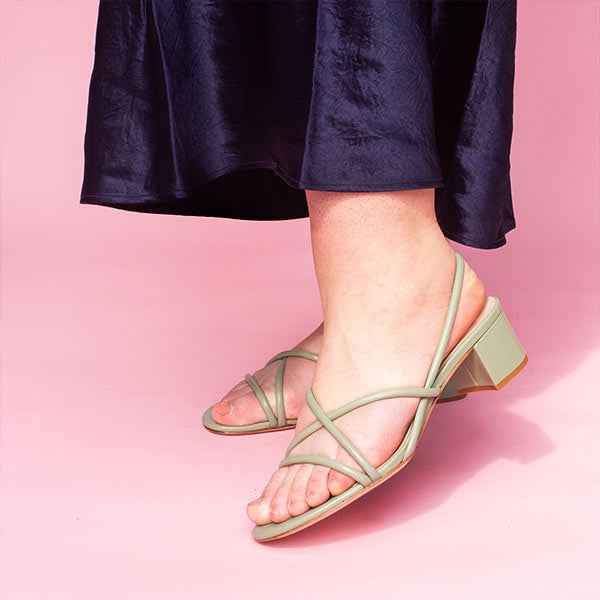 Mi/Mai Nelly strappy slingback sandal with mid block heel in sage green modelled with a navy satin dress