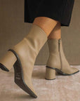ALOHAS west cape cactus warm beige ankle boot on model facing diagonally backwards wearing black skirt