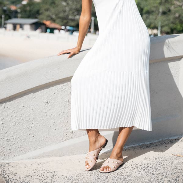 model on concrete bridge wearing white dress and pink leather Billi Bi crossover slides with gold stud detail
