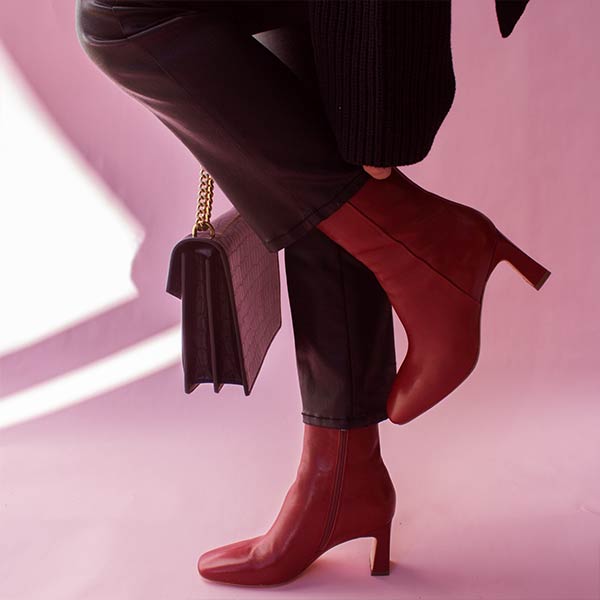 Mi/Mai Darcy mid heel ankle boot in red leather onn model wearing black jeans and sweater with black bag 
