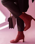 Mi/Mai Darcy mid heel ankle boot in red leather onn model wearing black jeans and sweater with black bag 